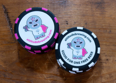 Drink tokens for Attitude Brewing on black and black with pink stripe poker chips